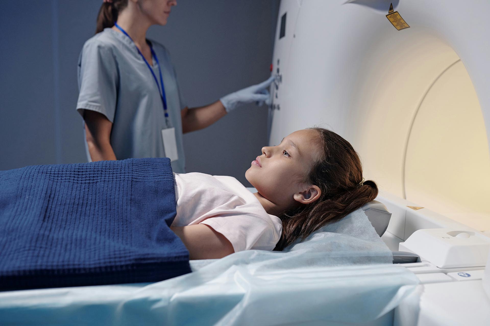 Barn ligger på en brits, en magnetröntgenmaskin syns till höger i bilden