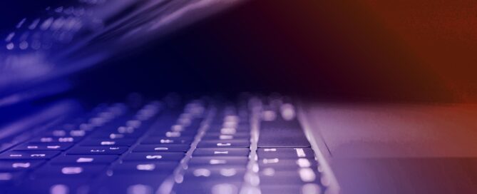 Bild på en bärbar dator som nästan är stängd. Bilden har en ton som går från blått till orange