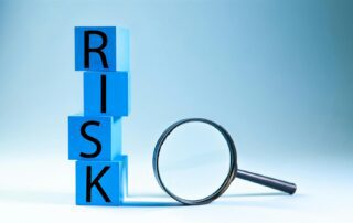 Blå bakgrund med klossar där det står risk, bredvid finns ett förstoringsglas