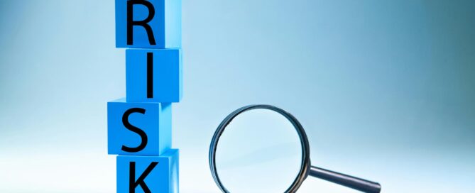 Blå bakgrund med klossar där det står risk, bredvid finns ett förstoringsglas