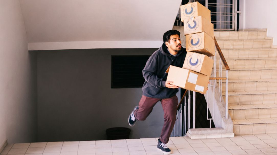 josue-sanchez-t-ii1ibAtq4-unsplash-ext Person bärandes på paket ramlar i trappa